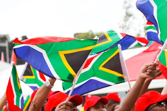 Grupo de personas ondeando la bandera sudafricana