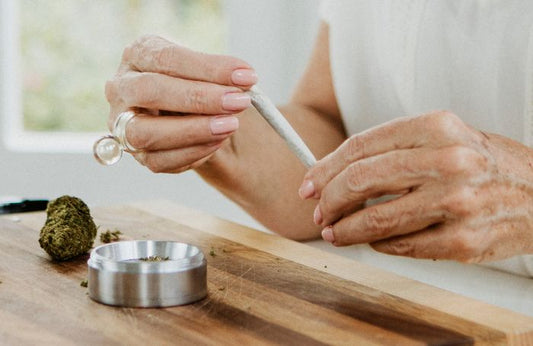 Persona mayor sosteniendo un porro de marihuana