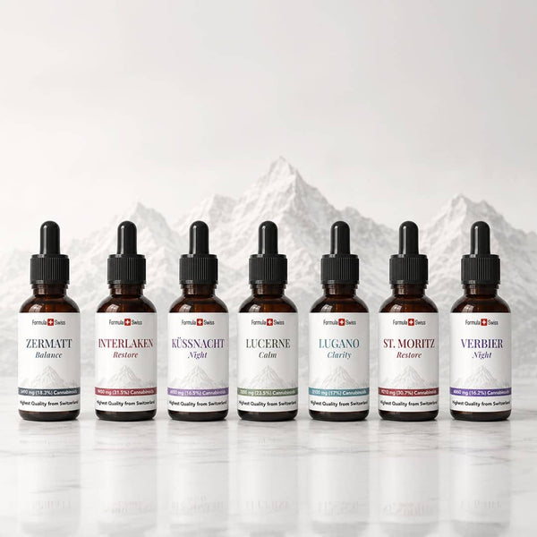Colección de aceite de CBD suizo de fórmula con siete botellas de cuentagotas de amber expuestas frente a un fondo de montaña suizo.