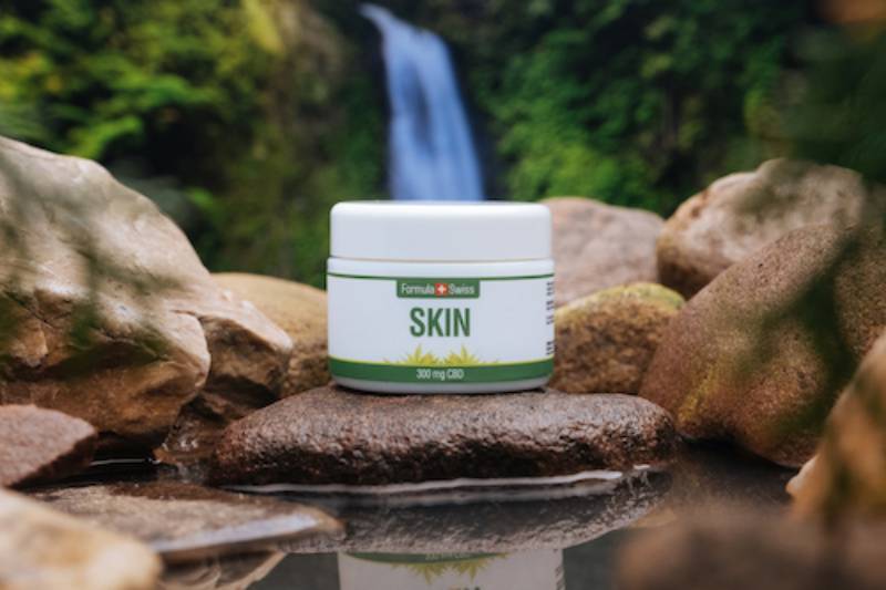 Tarro del bálsamo CBD Skin de Formula Swiss junto a una cascada